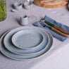 Handmade dinner plate with organic shape and blue grey speckle glaze colour 