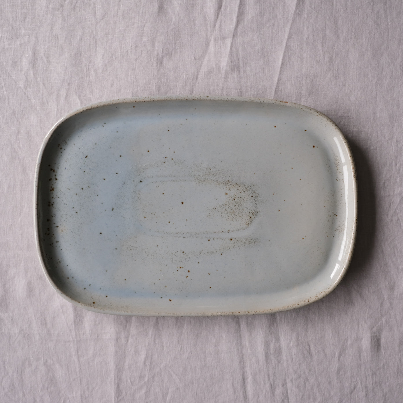 Handmade blue grey rectangle platter made from stoneware on a grey tablecloth by Palinopsia ceramics