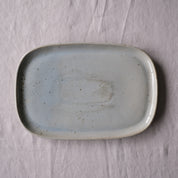 Handmade blue grey rectangle platter made from stoneware on a grey tablecloth by Palinopsia ceramics