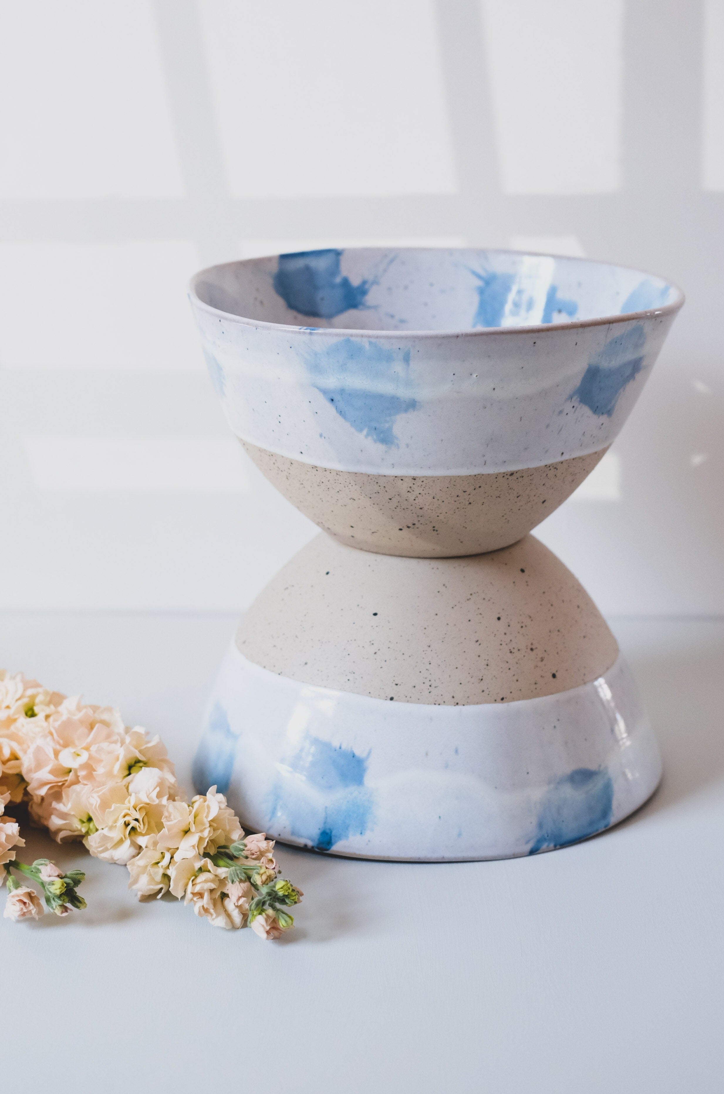 Two Pollock blue and white handmade fruit bowls stacked with wild flowers