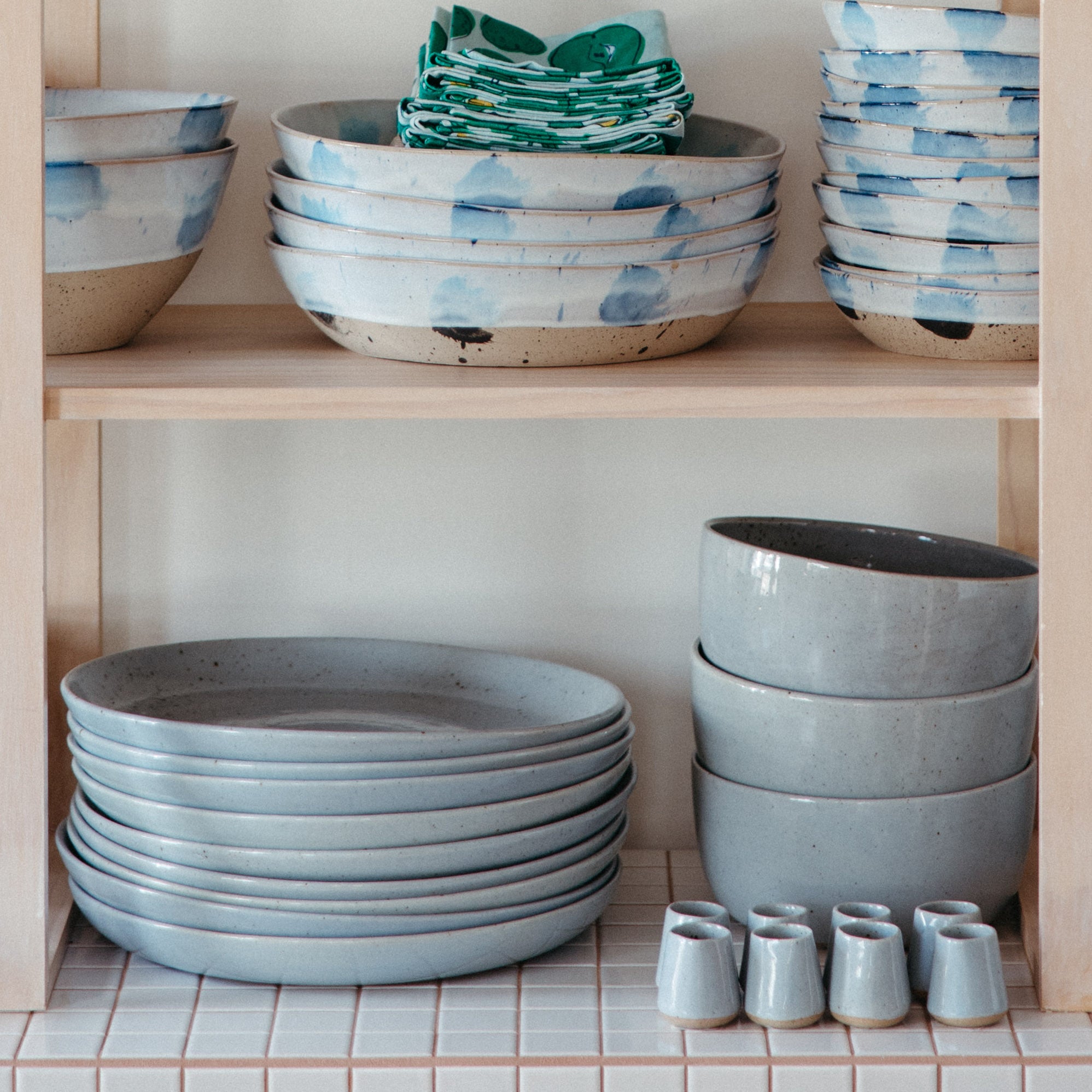 Ceramics serving accessories stacked on a shelf by Palinopsia