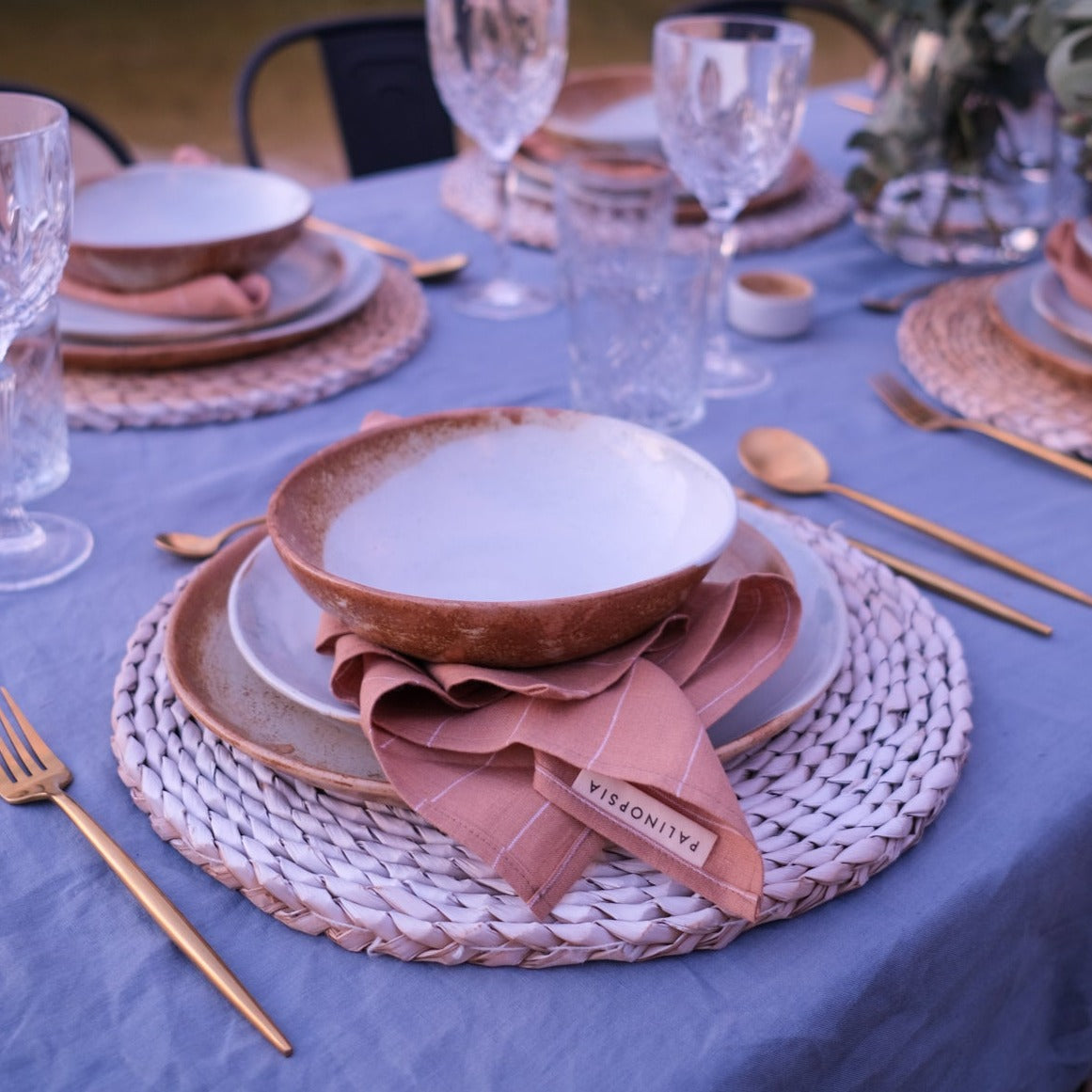 Outdoor table setting with vintage inspired dinnerware in blues and browns, dinner plate, lunch plate and soup bowl