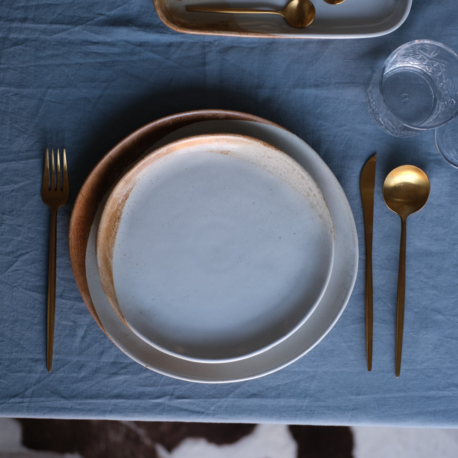 Birds eye-view of a handmade lunch plate side plate by Palinopsia Ceramics in rustic browns and blues and soda fired