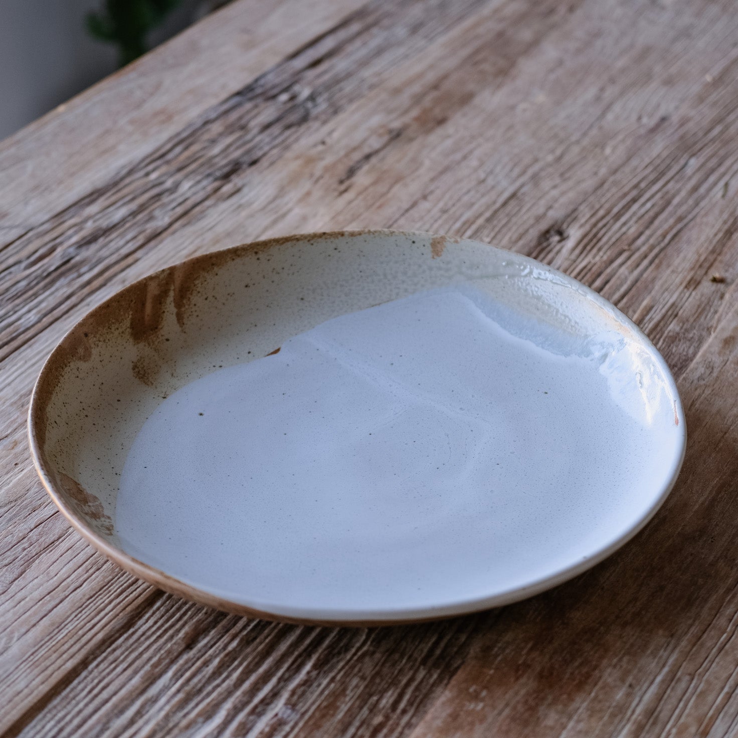 Sideview of a large serving platter by Palinopsia Ceramics made from stoneware and of brown and rustic blue glazes
