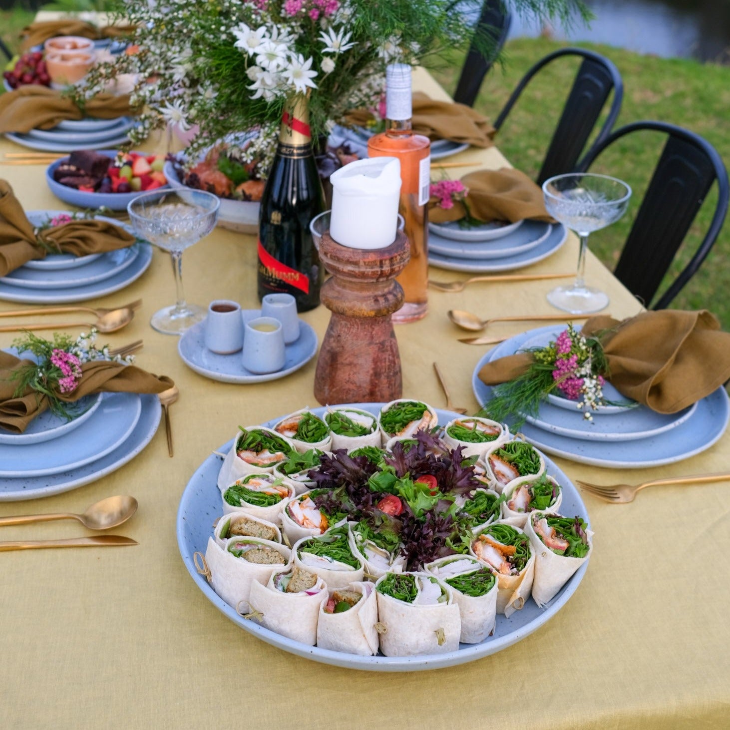 Large round serving platter plate in blue by Palinopsia Ceramics on yellow linen tablecloth