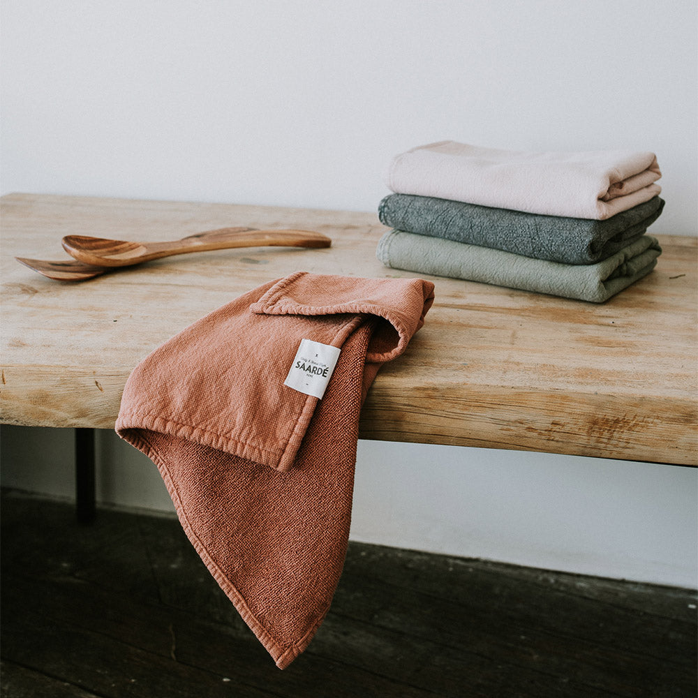 Vintage washed tea towels stacked in dusty colours