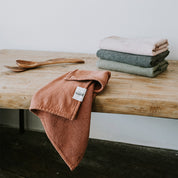 Vintage washed tea towels stacked in dusty colours