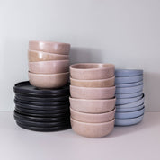 Stacked handmade dinner plates and bowls by Palinopsia Ceramics in blue, black and pink mushroom greys from Sydney Australia