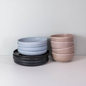 Side view of a stack of handmade dinner set by Palinopsia Ceramics in block colours of black Ink, powder blue and mushroom grey in Newcastle Australia
