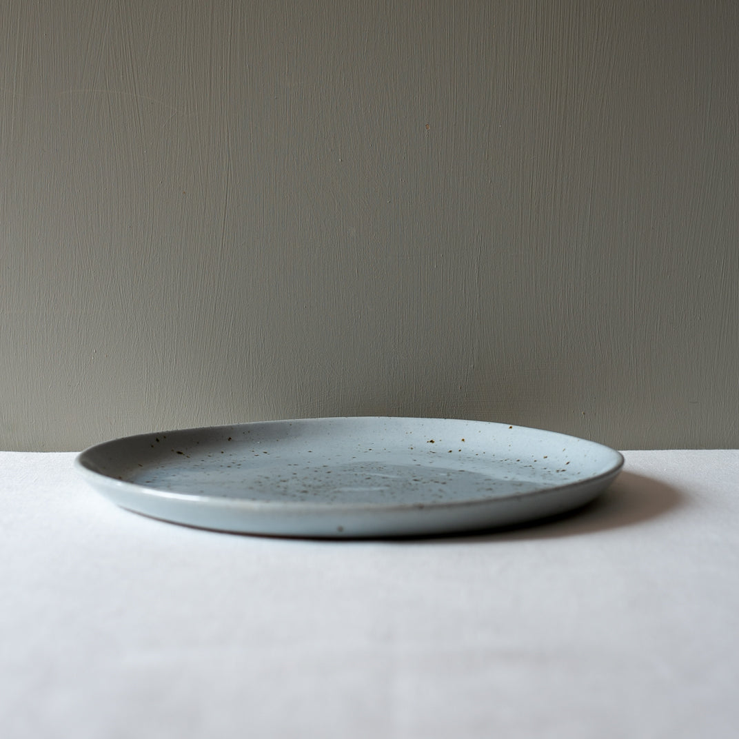 Side view of a large round handmade dinner plate