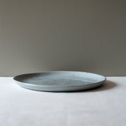Side view of a large round handmade dinner plate