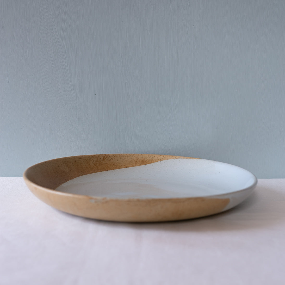 Side view of a large round serving platter handmade by Palinopsia Ceramics