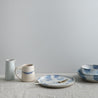 Handmade pottery and dinnerware in blue and white against a white background by Palinopsia Ceramics 