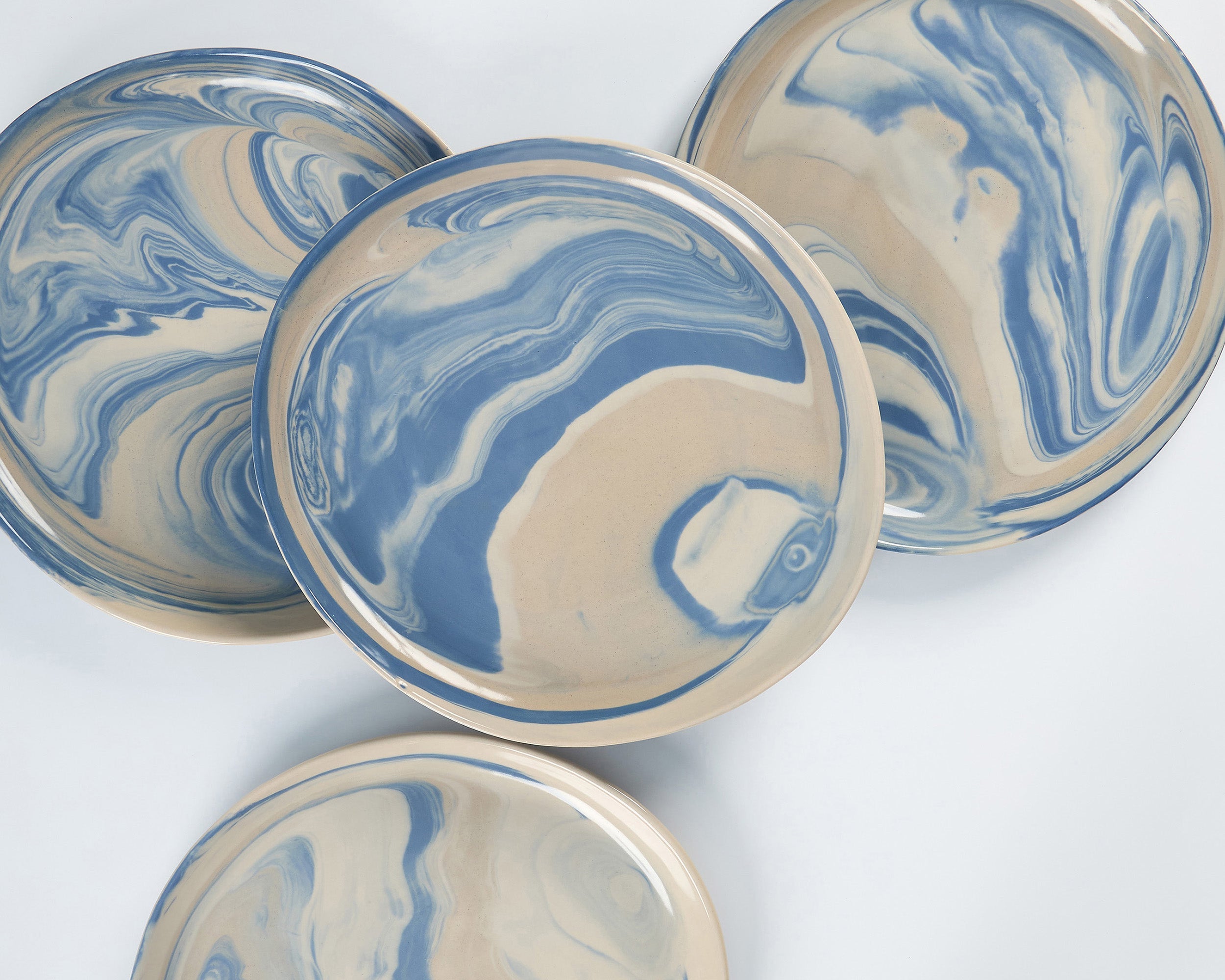 Dinner plate set of Palinopsia ceramic bowls with blue and white marbled pattern on a white background