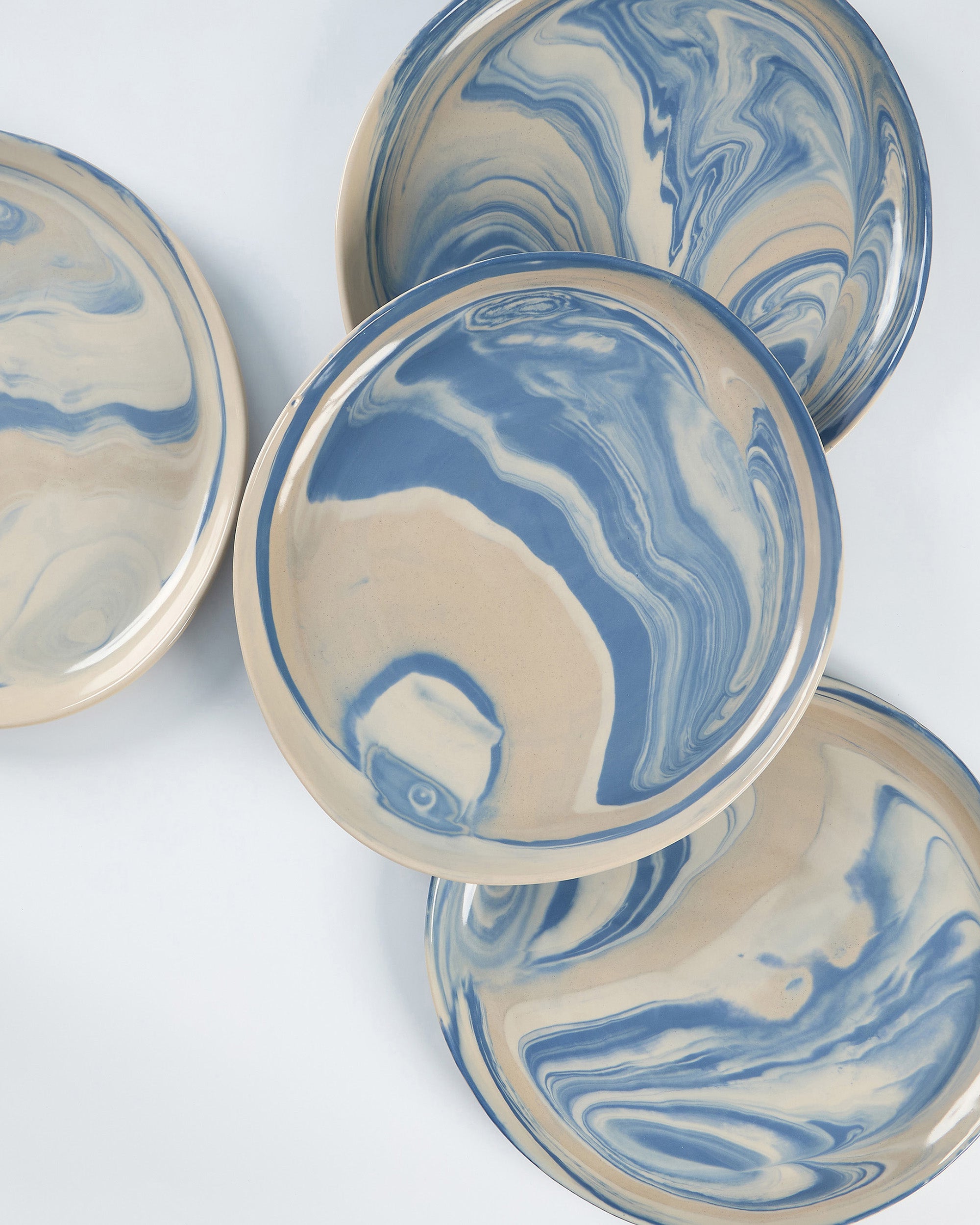 Dinner plate set of Palinopsia ceramic bowls with blue and white marbled pattern on a white background