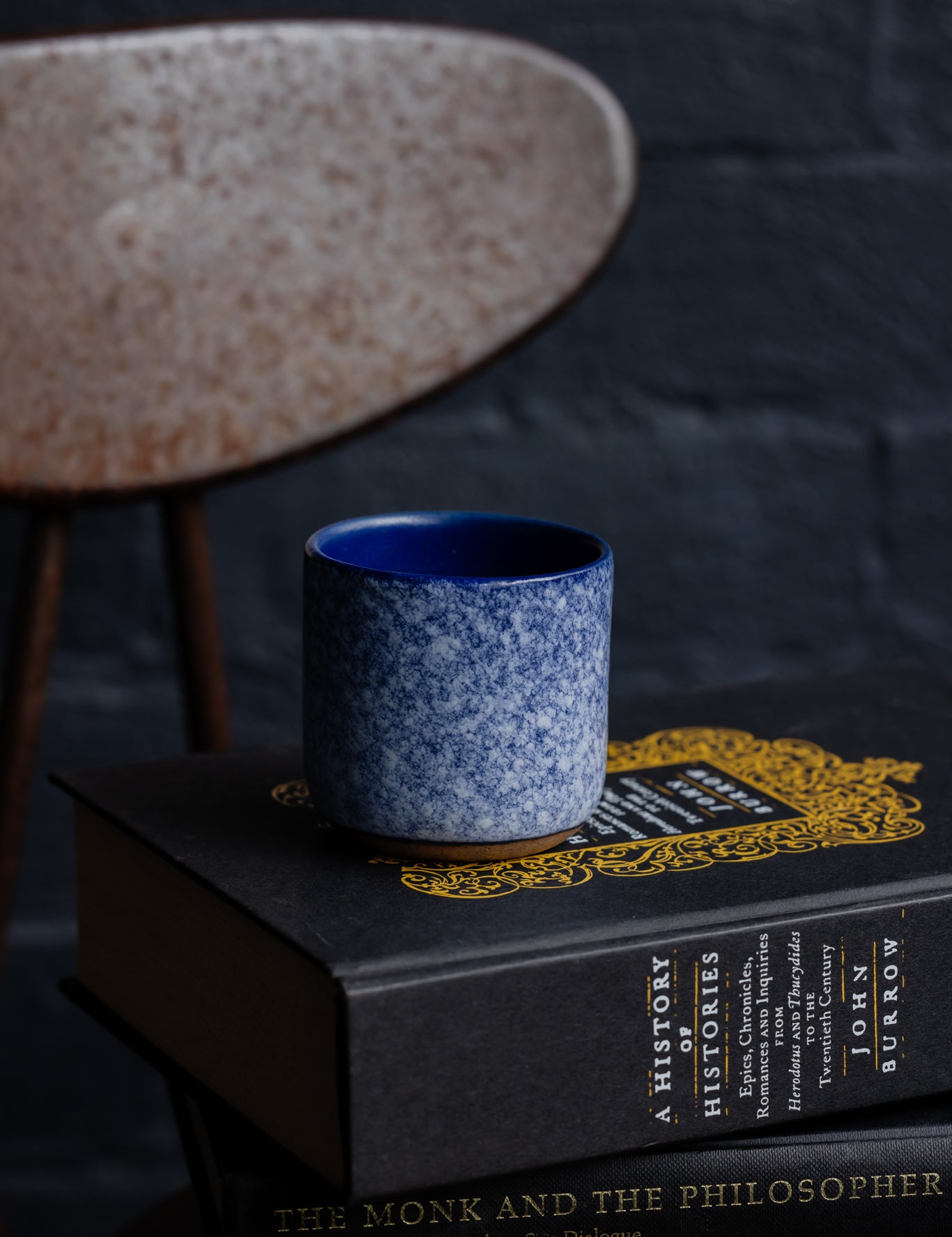Handmade espresso cup sitting on top of stacked books