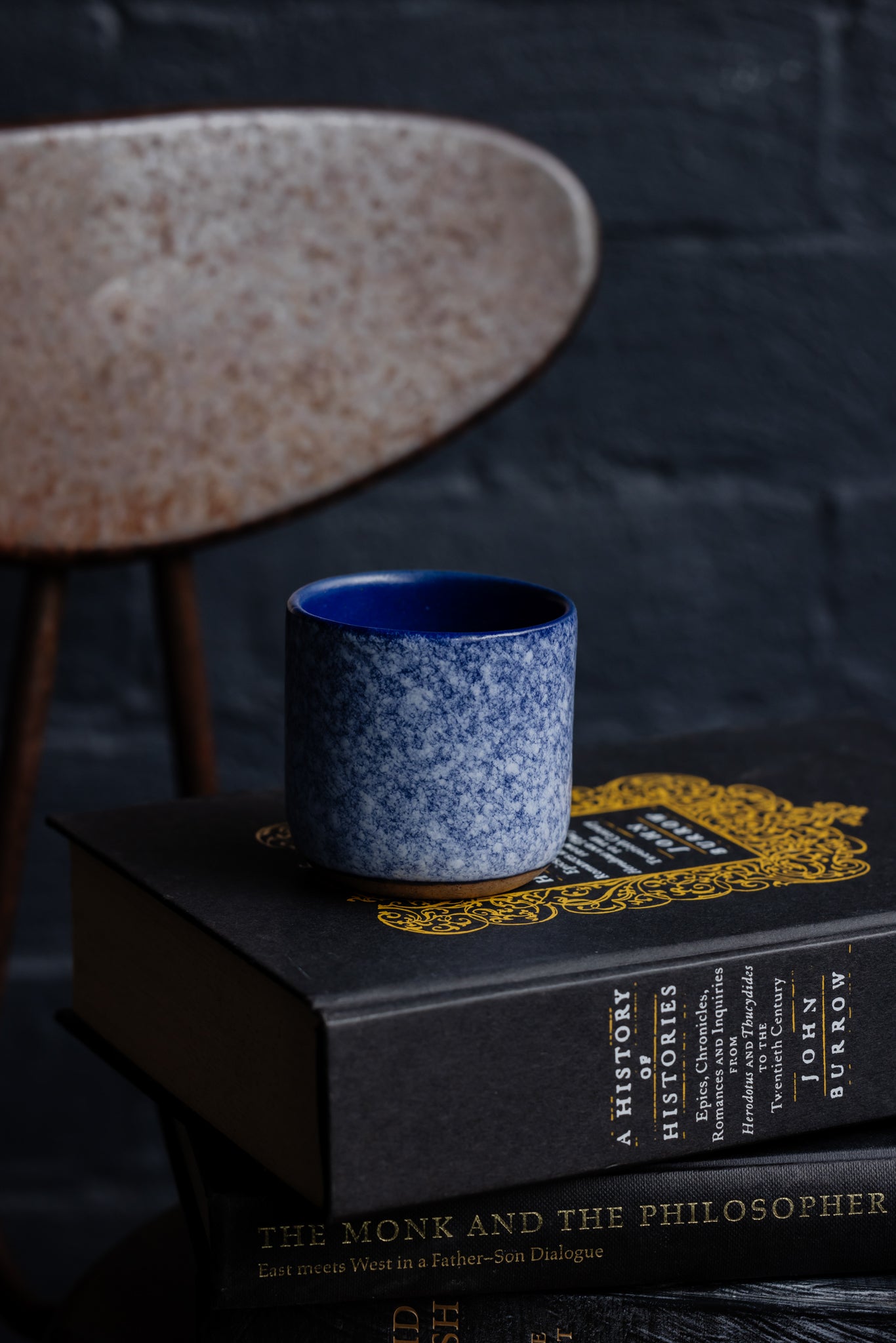 Handmade espresso cup sitting on top of stacked books