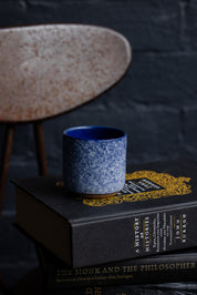 Handmade espresso cup sitting on top of stacked books