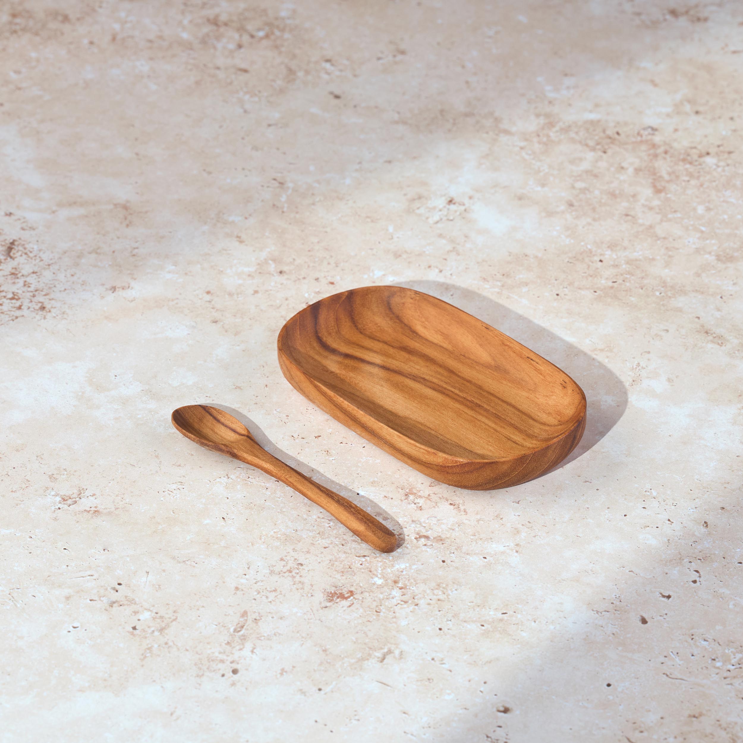 Palinopsia teak wooden tray and teak spoon on a light stone surface