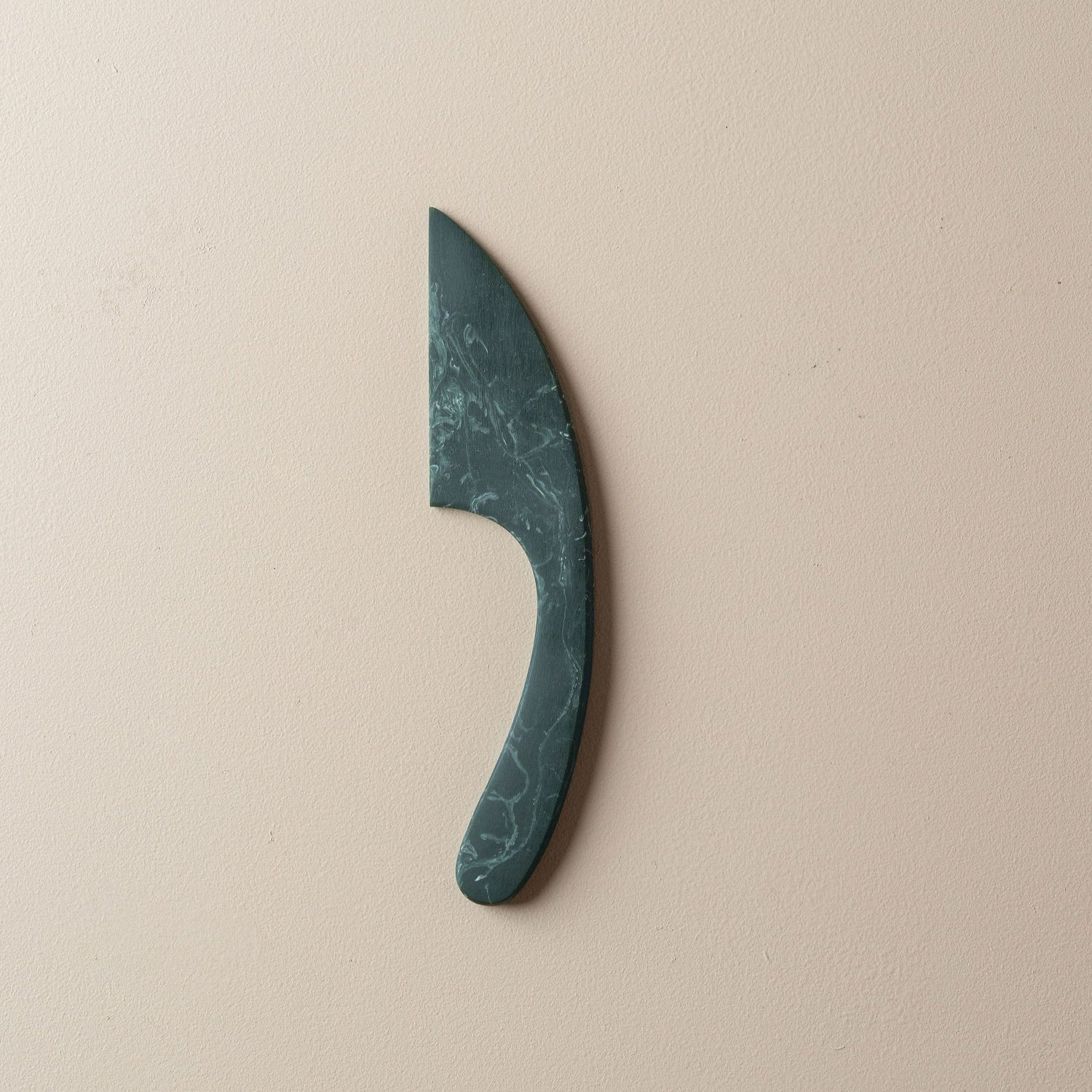 Resin Jade Green curved cheese knife on a beige background