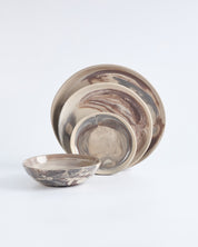 Set of ceramic bowls and plates with marbled design on a white background