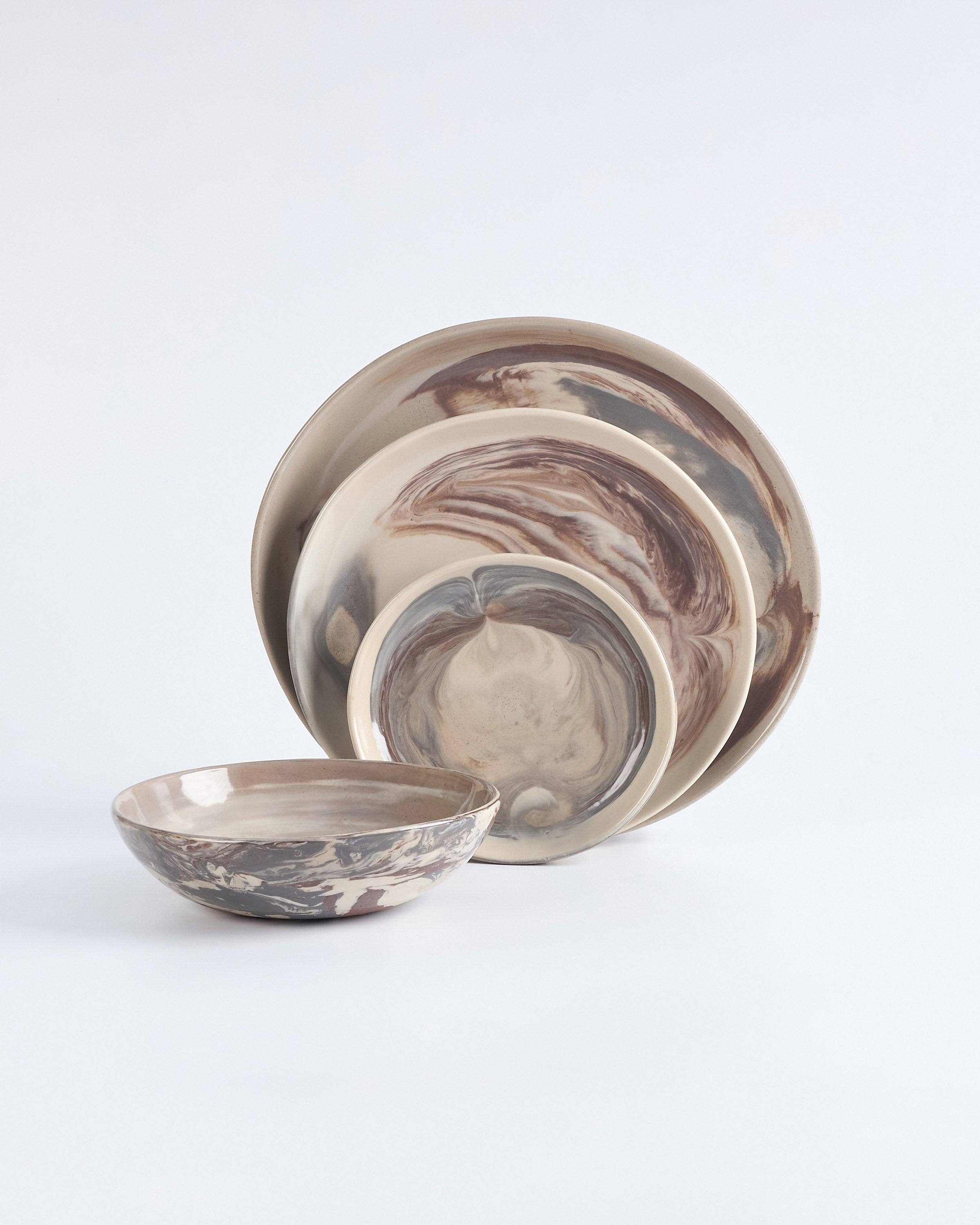 Set of ceramic bowls and plates with marbled design on a white background