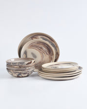 Set of four ceramic bowls and plates with marbled design on a white background. 