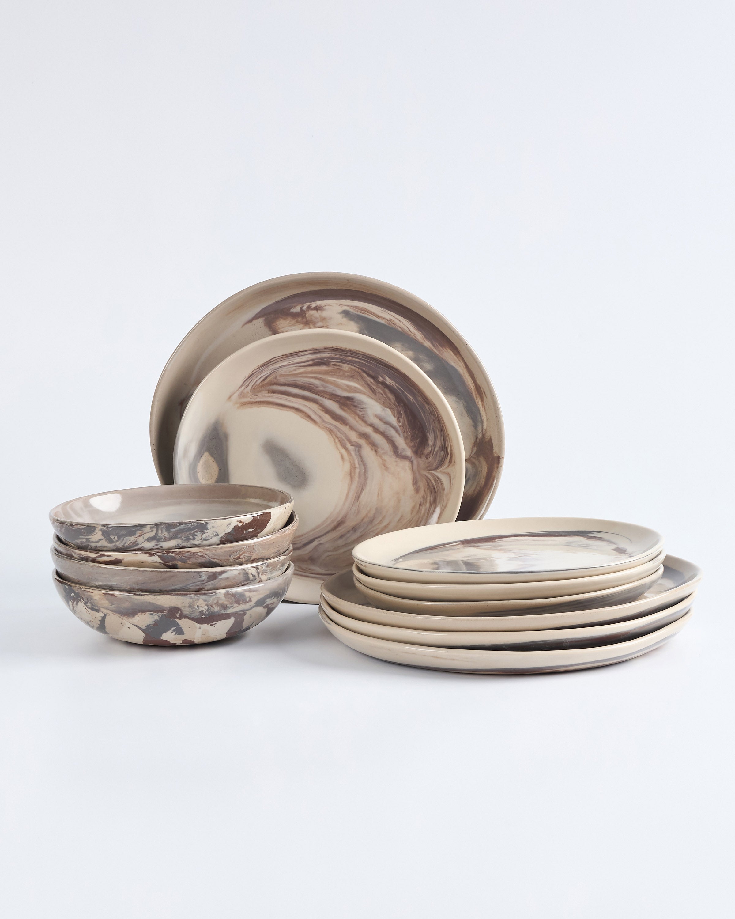 Set of four ceramic bowls and plates with marbled design on a white background. 