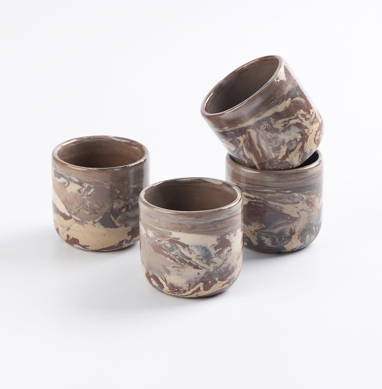 Set of four marbled ceramic cups on a white background