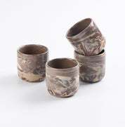 Set of four marbled ceramic cups on a white background