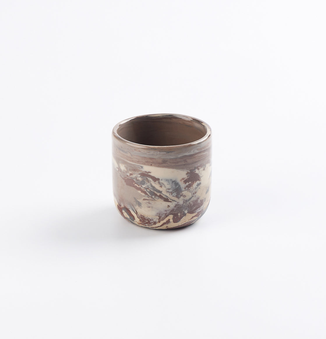Ceramic espresso cup with four clay marbled design on a white background