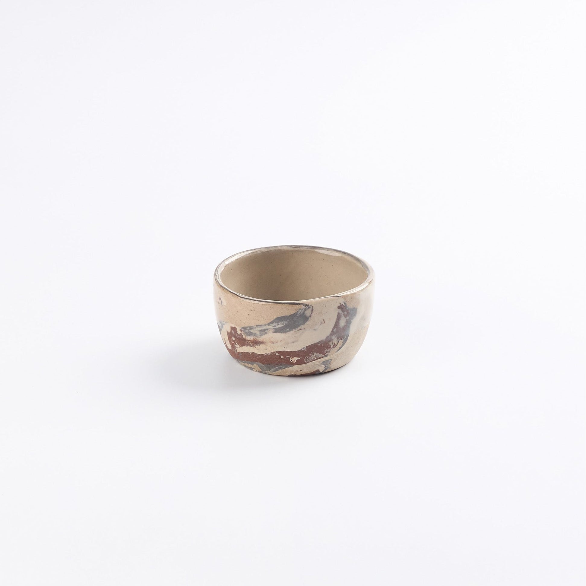Small marbled ceramic dip bowl in neutral tones against a white background 
