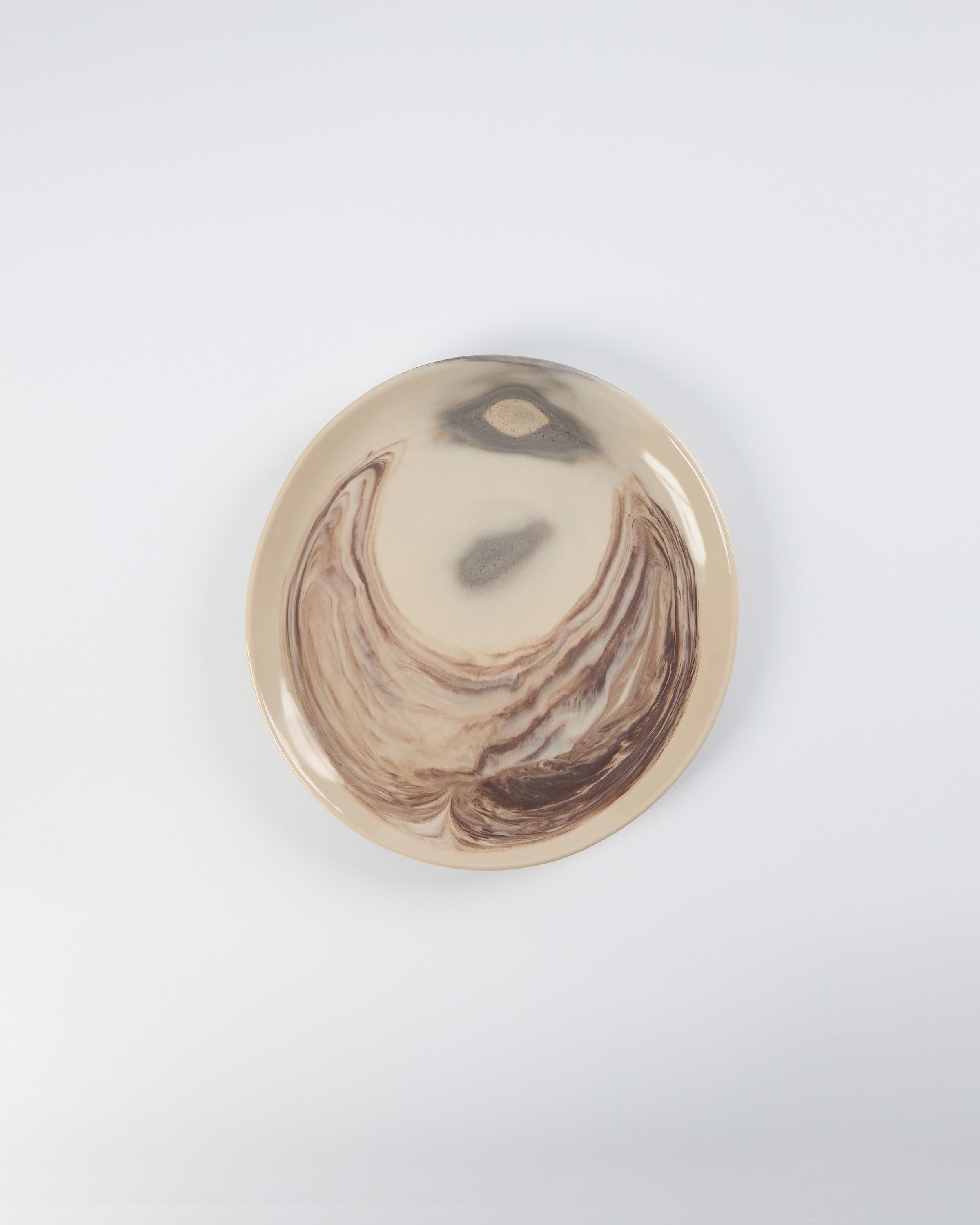 Round decorative item with marbled design on a white background