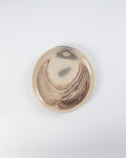 Round decorative item with marbled design on a white background