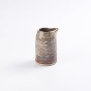 Ceramic hand pourer pitcher with marbled design on a white background