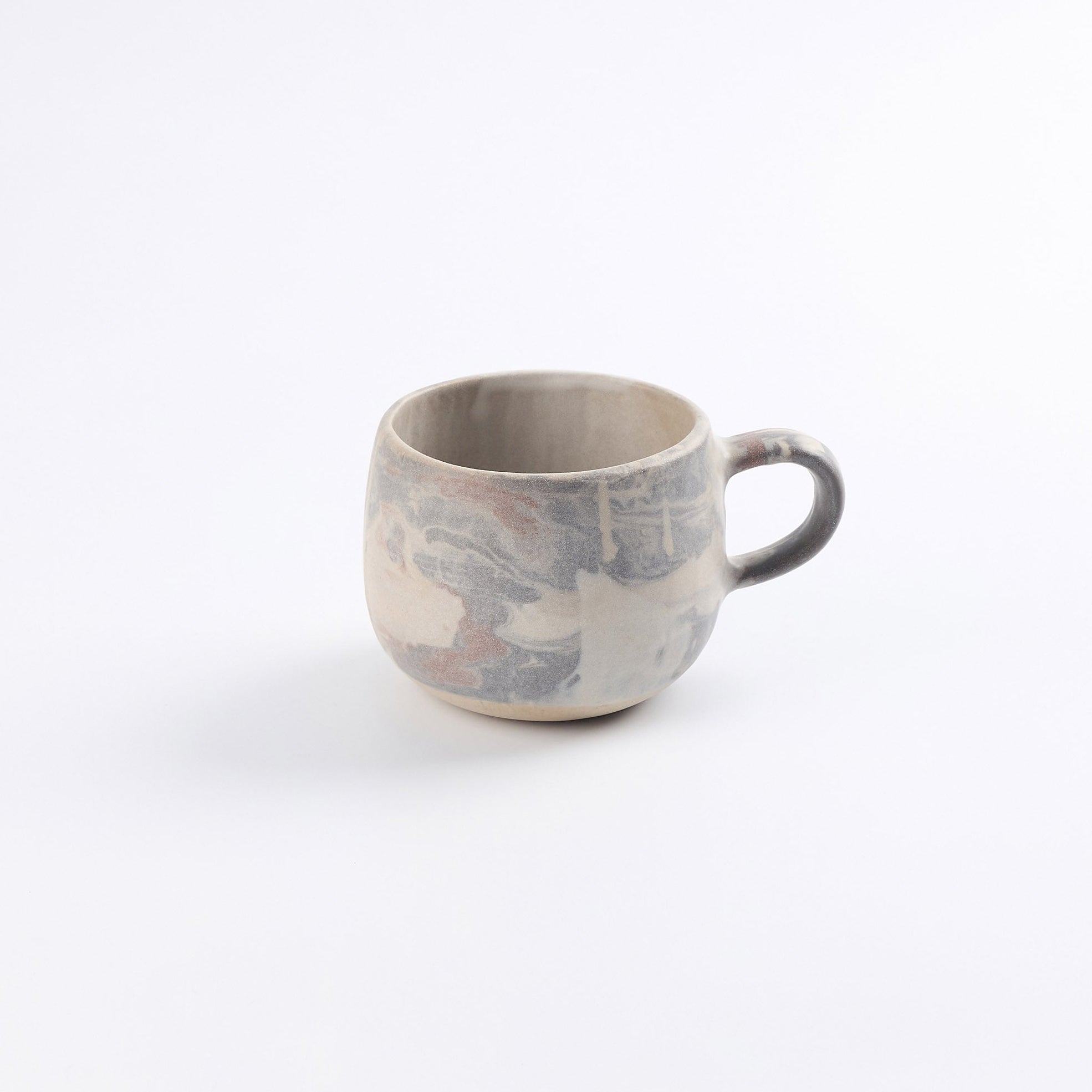 Stoneware ceramic mug with abstract marble pattern and a pure matte glaze on a white background