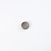 Birds eye view of a small ceramic salt dish in neutral colours on white background 