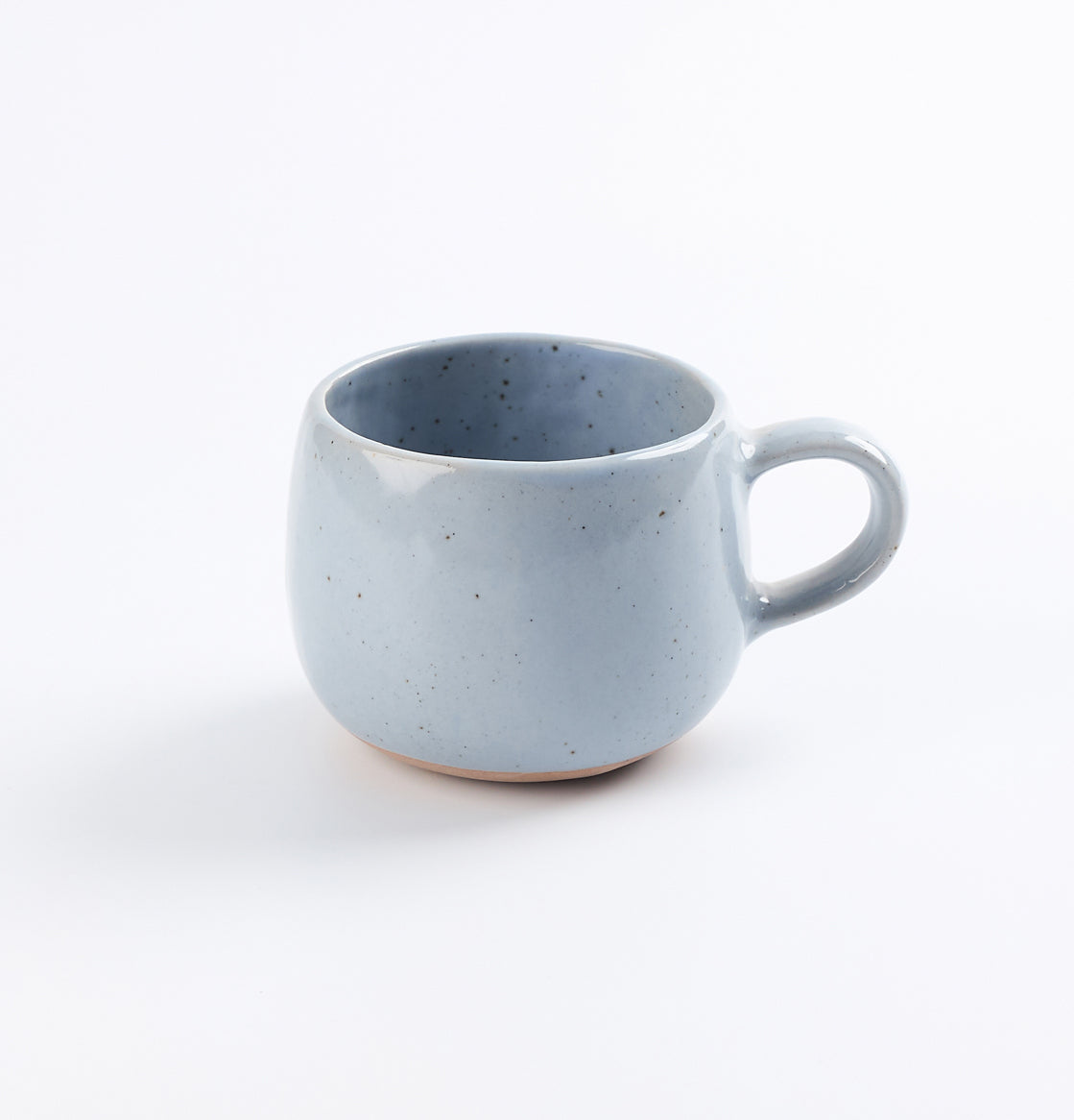 Handmade blue speckled ceramic mug on a white background