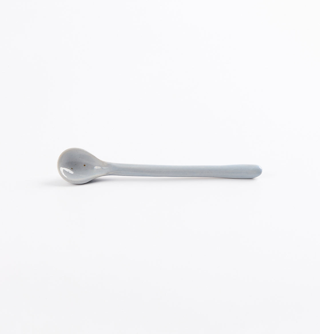Ceramic spoon with speckles on a white background