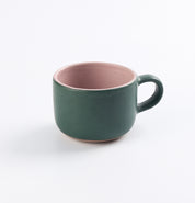 Green and pink stoneware mug by Palinopsia on a white background 