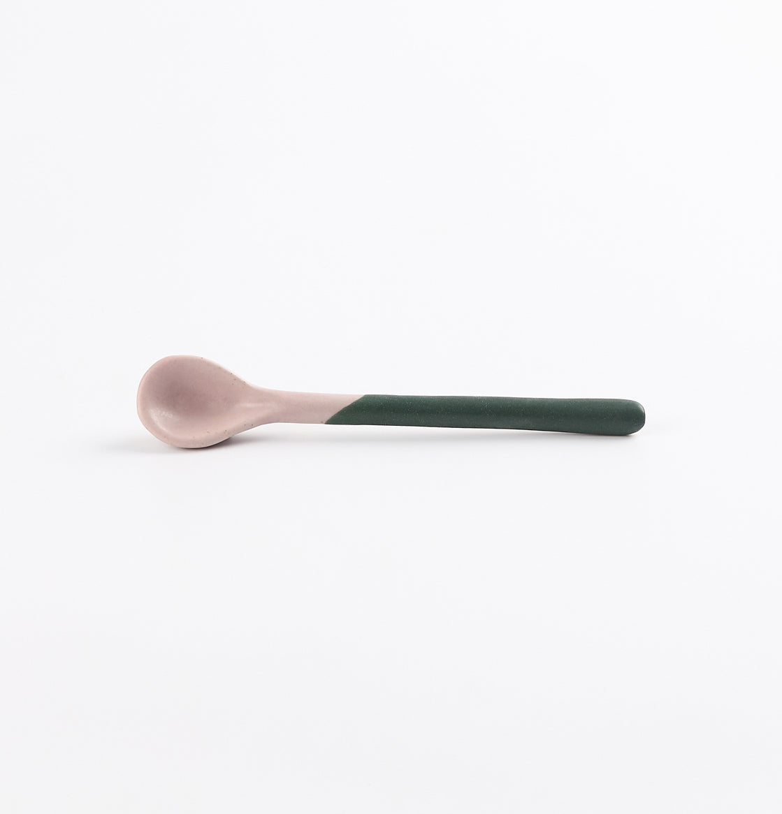 Ceramic spoon with a green handle and pink tip on a white background