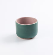 Palinopsia's green ceramic stoneware cup with pink interior on a white background