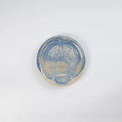 Small handmade ceramic plate with a marbled clay pattern in cobalt blue, beige and cream on a white background by Palinopsia