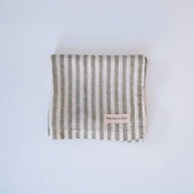 Green and white striped linen fabric on a light blue background
