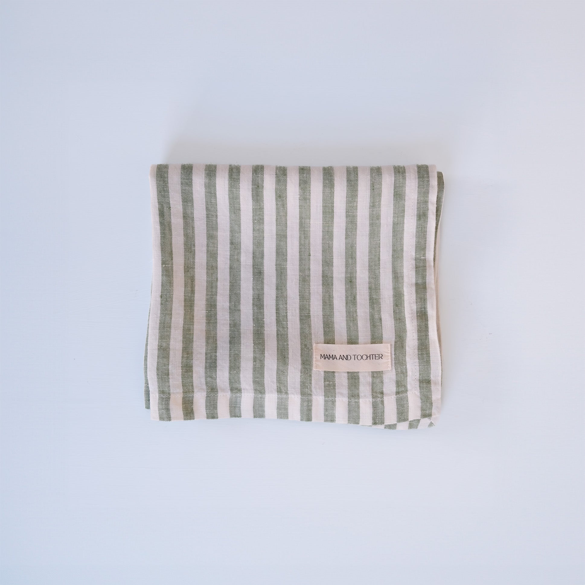 Green and white striped linen fabric on a light blue background