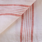 Close-up of red striped linen tea towel fabric on a white background