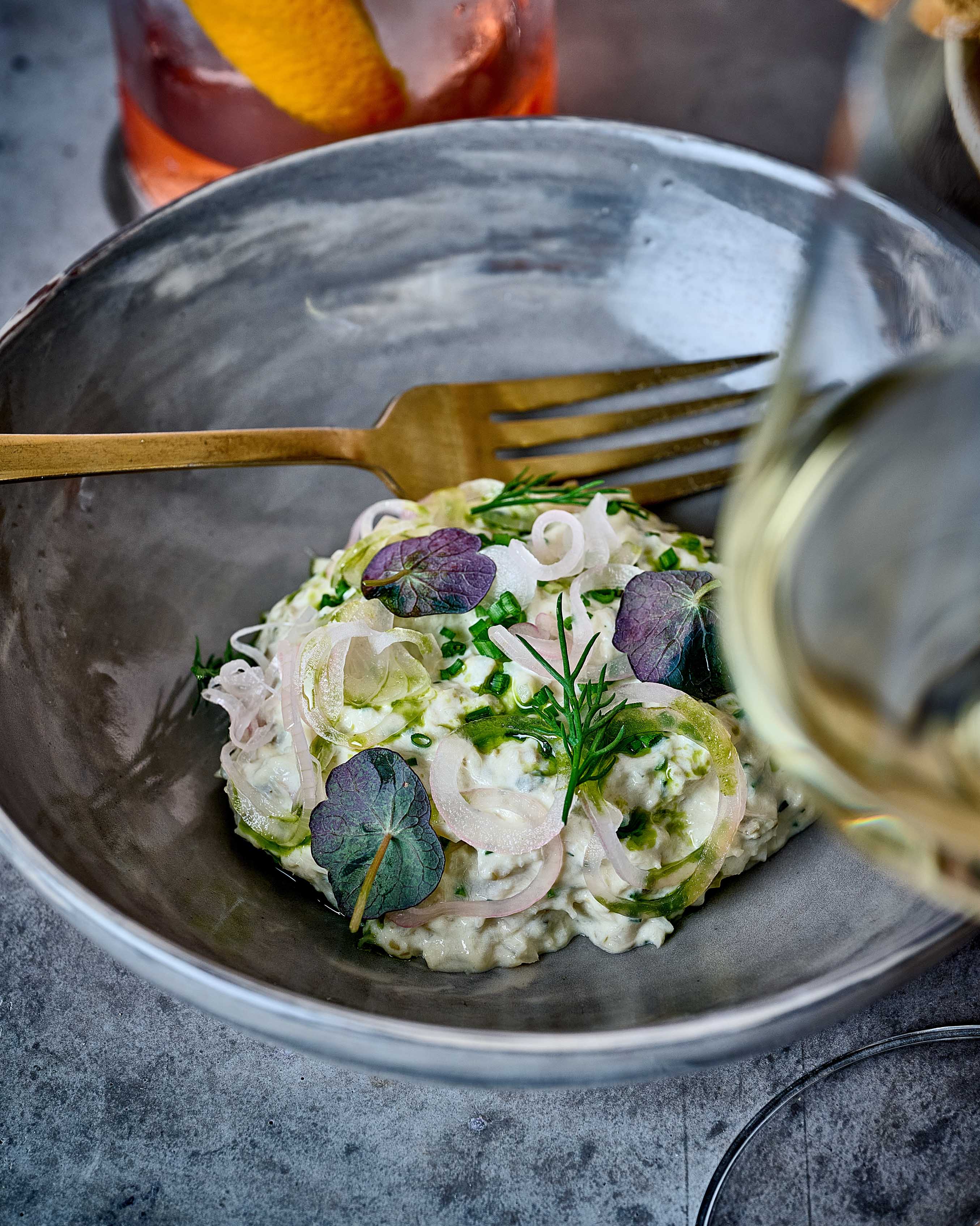 Potato salad in marbled bowl with a gloss of white wine
