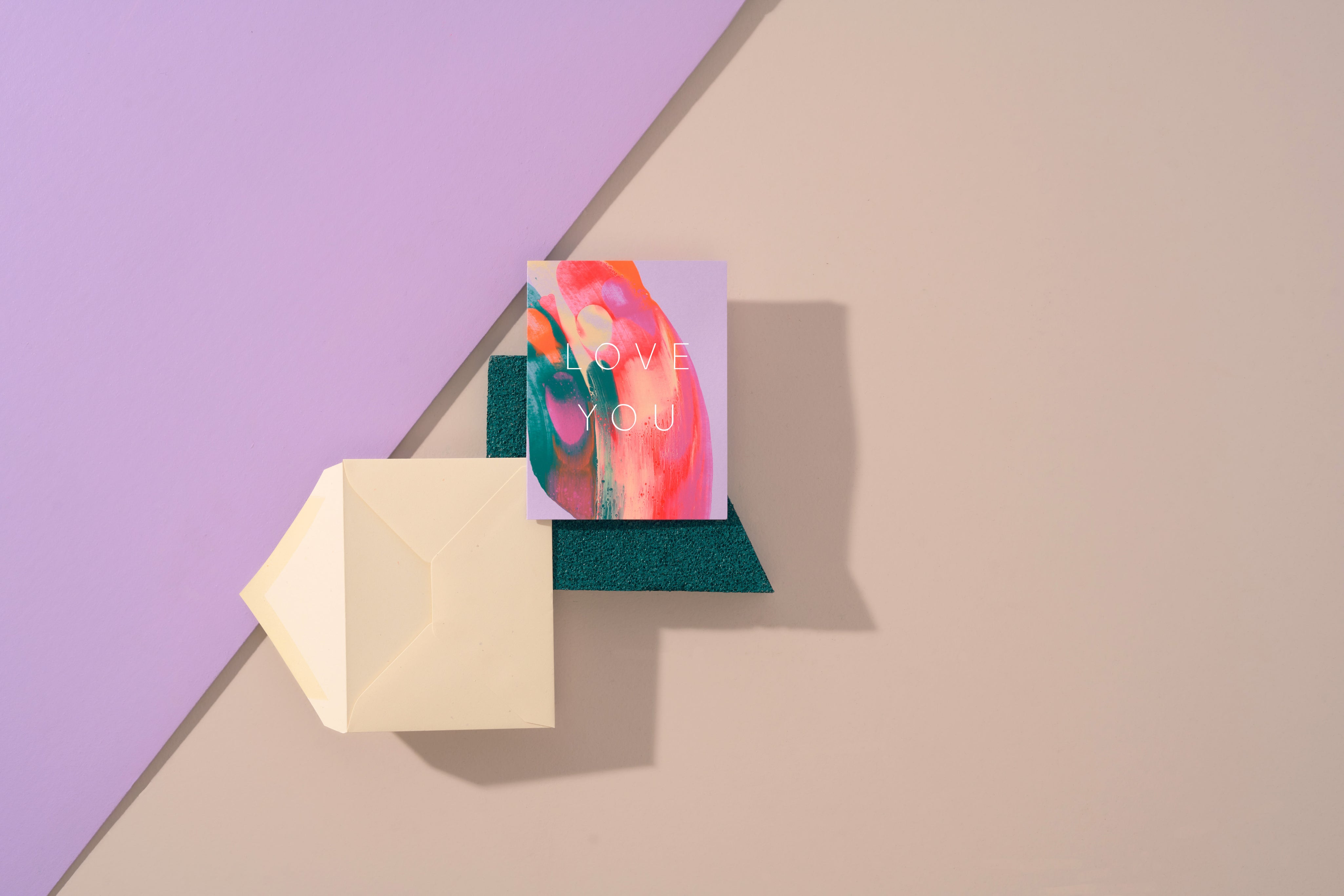 Love You Greeting card with colorful design and envelope on a geometric background