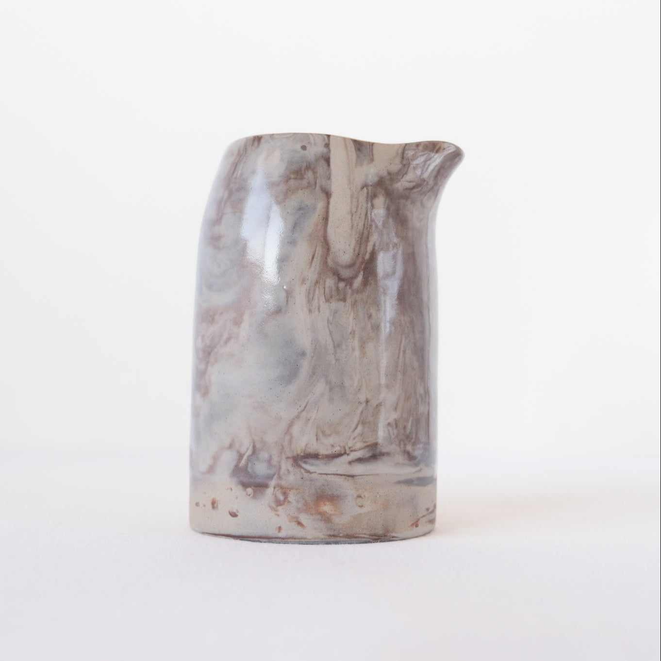 Ceramic pitcher with marbled design and clear gloss glaze 