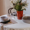 Table setting at Palinopsia's Newcastle store with white tablecloth, and handmade ceramic dinner set and low salad bowl in monochrome colours